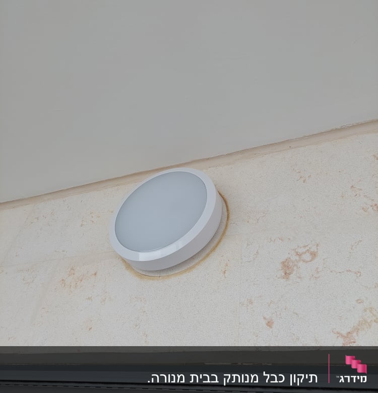 מנורת קיר עגולה מותקנת על קיר חיצוני